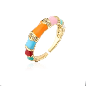 Detail of 18K gold-plated ring showing colorful enamel segments and zircon inlay