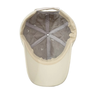 Quilted interior view of a beige baseball cap with star embroidery and velcro strap