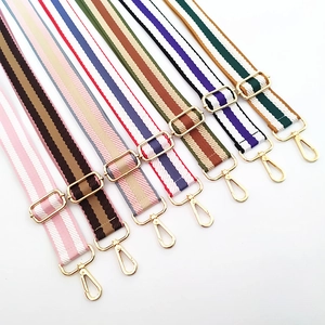 Detailed view of colorful striped adjustable bag straps with golden metal hardware