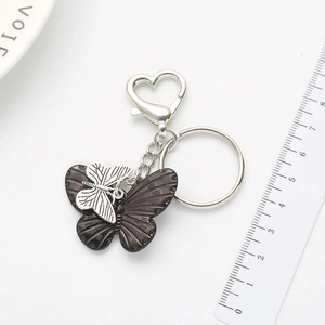 Dual-layer butterfly pendant keychain with heart-shaped clasp on white background