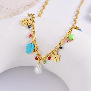 Golden pearl necklace with tree of life, colorful heart and leaf pendants on white stand
