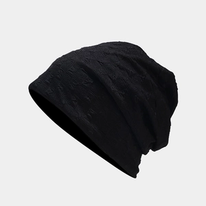 Detailed view of black slouchy beanie featuring 3D embossed geometric knit textures