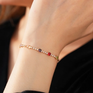 Close-up of vintage gold tennis bracelet with colorful round-cut zircons on a wrist