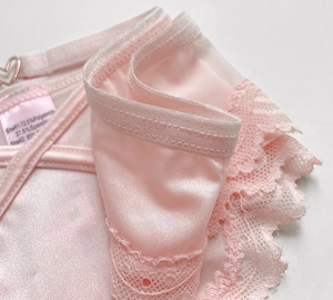 Macro shot of pink lace texture and heart hollow-out detail on ice silk thong
