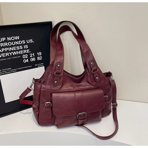 Detail view of burgundy faux leather tote bag showing pockets and adjustable strap