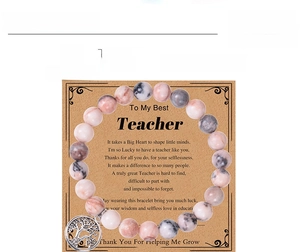 Détail des perles en pierre zébrée rose 8mm et pendentif arbre de vie sur bracelet élastique