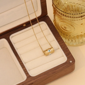 Collier avec pendentif œil maléfique en acier doré dans un coffret à bijoux en bois