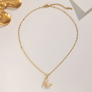 Detail of golden butterfly pendant with pink wings and sparkling zircon inlay
