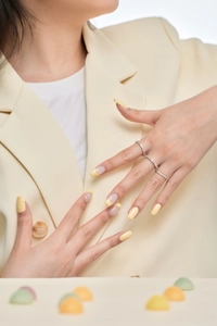 Close-up of slender S925 silver rings with pink and white zircon on a model's hand