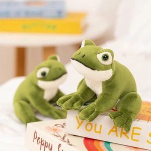 Two realistic green frog plush toys in sitting poses on decorative books for home decor
