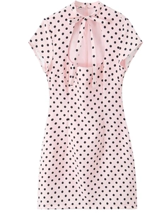 Detail of pink polka dot short dress featuring a high neck bow and teardrop cutout design