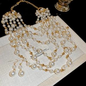 Detail of multi-layer pearl necklace and gold earrings set on vintage card