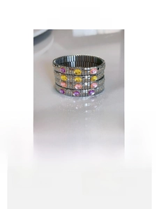 Detail of stainless steel stretch bracelet featuring purple and yellow oval crystals