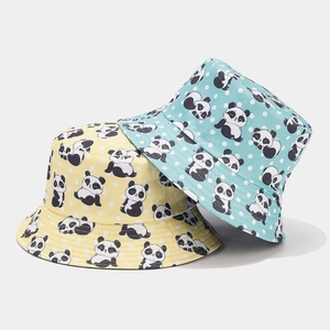 Detail of yellow and blue reversible bucket hats with cute panda and polka dot prints