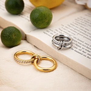 Detail of 18k gold and silver layered rings with zircon inlay on a creative background