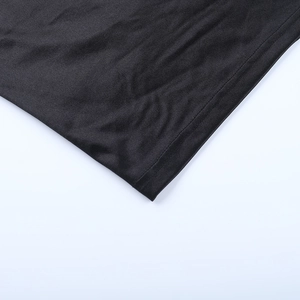 Vue détaillée macro montrant l'ourlet précis à double aiguille et la texture du tricot noir