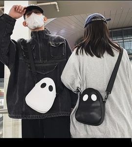 Close-up of cute ghost-shaped PU leather crossbody bag with eye patches and nylon strap