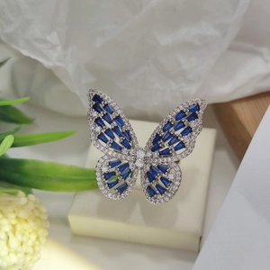 Macro detail of silver ring featuring butterfly wings with blue zircon stones