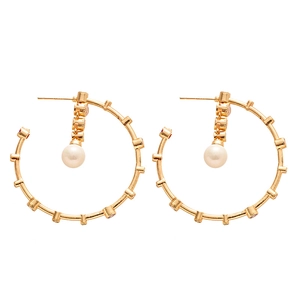 Golden C-shaped earrings with red zircon accents and elegant hanging pearls on white background