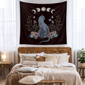 Detailed view of cat tapestry with floral and moon phase patterns in a cozy bedroom