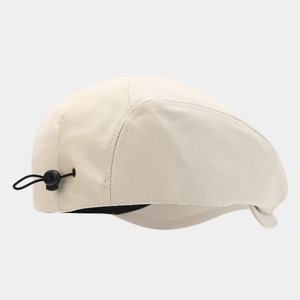 Detail view of the beige newsboy hat with adjustable elastic drawstring and buckle