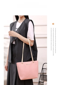 Detail of pink chevron quilted handbag with thick braided rope handle and metal logo