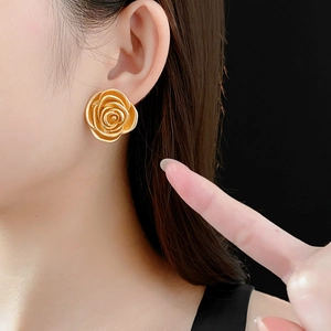 Close-up of matte gold vintage rose flower earrings on model with high quality finish