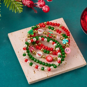 Dettaglio del set di cinque braccialetti natalizi con perline e ciondoli festivi