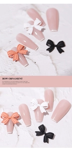 Detail of 3D bow nail art ornaments in pink, white, and black on long nails