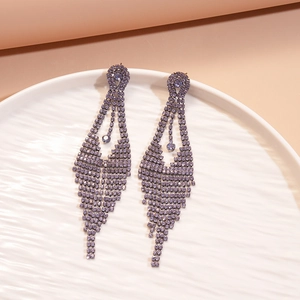 Detailed view of long purple rhinestone tassel earrings with a silver needle setting