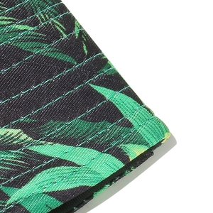 Macro shot of tropical leaf print canvas hat with reinforced parallel stitching seams