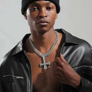 Detail of hip hop iced out inverted cross pendant on cuban link chain for men