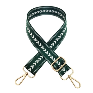 Detail of adjustable dark green arrow pattern strap with golden metal snap hooks