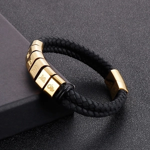 Detail shot of black braided double leather bracelet with golden Buddhist mantra beads