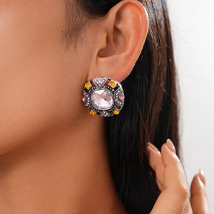 Close-up of vintage geometric earrings with pink and purple rhinestones on model