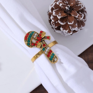 Detailed close-up of a golden candy cane napkin ring with red and green rhinestones