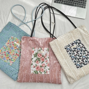 Three stylish tote bags in blue sequins, pink velvet and beige lace with brand logo label