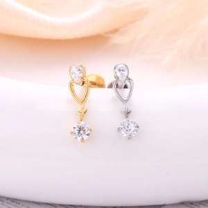 Detail of titanium heart earrings with cubic zirconia stones in gold and silver