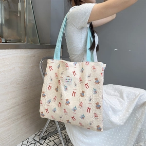 Detail of embossed waffle fabric shoulder bag featuring cute cartoon bears and rabbits