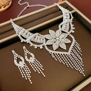 Detailed close-up of silver flower necklace and fringe rhinestone earrings set