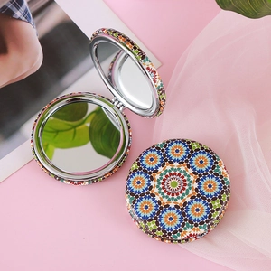 Foldable pocket mirror with colorful bohemian mandala pattern on soft pink background