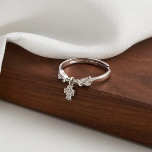Macro detail of S925 silver cross pendant ring with sparkling zircons on wooden surface