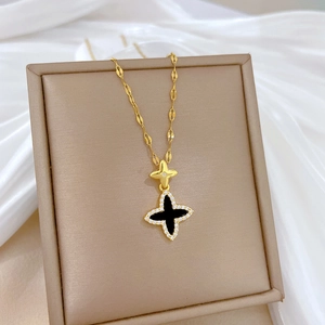 Detail of clover pendant necklace with black enamel inlay and white rhinestones on silk