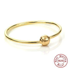 Detail of 925 sterling silver gold-plated nose ring with bead on white background