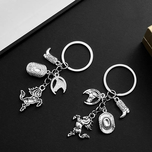 Detailed close-up of antique silver cowboy hat horse and boot charms on metal keychains