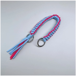 Close-up of blue and pink hand-woven nylon shoulder strap with metallic rings and fringe