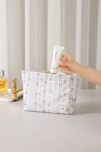 Detailed view of floral pattern and bow print on a lavender fabric cosmetic bag