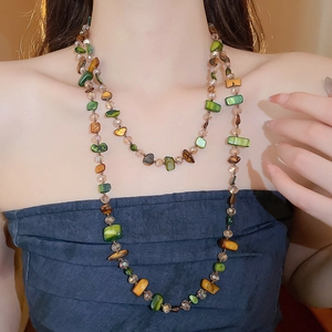 Close-up of irregular crystal stone necklace with colorful polished shell fragments