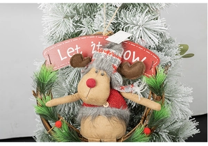 Detail of Christmas reindeer plush on vine wreath with festive Let it snow text