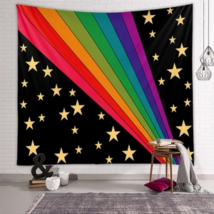 Rainbow striped tapestry with gold stars on black fabric hanging on a white brick wall
